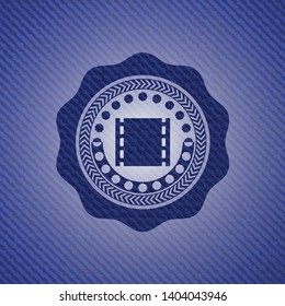 film icon inside emblem with jean background