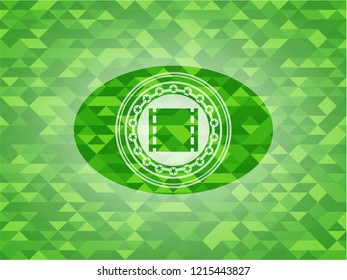 film icon inside green emblem. Mosaic background