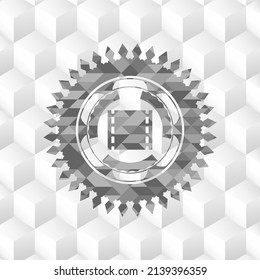 film icon inside realistic grey emblem with geometric cube white background. 