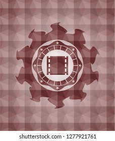 film icon inside red seamless emblem or badge with abstract geometric polygonal pattern background.