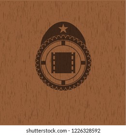 film icon inside retro style wooden emblem