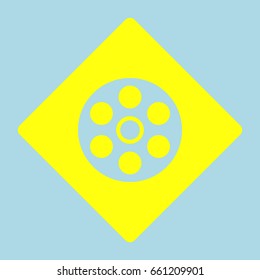 Film icon. Vector. Yellow romb with hole as icon on lightblue background.