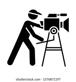 Film industry glyph icon. Cinema business. Cinematography. Operator filming scene. Filmmaking. Moviemaking. Video production. Silhouette symbol. Negative space. Vector isolated illustration