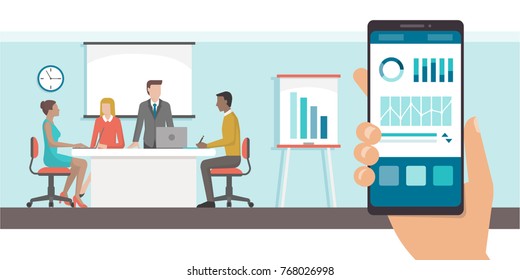 Finance and administration app with charts on a smartphone and business meeting in the office on the background