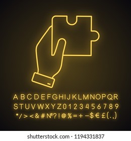 Finding solution neon light icon. Problem solving. Teamwork. Hand holding puzzle. Glowing sign with alphabet, numbers and symbols. Vector isolated illustration