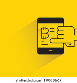 finger touching on smartphone with bitcoin icon on yellow background