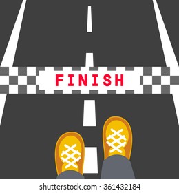 Finish line road sign. Man feet standing on the road in front of the end stop band.