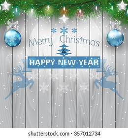 Fir branches and christmas light bulb on wooden background