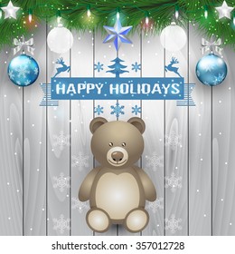 Fir branches teddy bear and christmas light bulb on wooden background