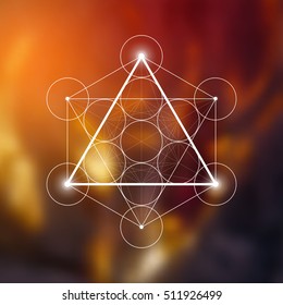 Fire element symbol inside Metatron Cube and Flower of Life in front of natural blurry background. Sacred geometry magic symbol futuristic vector design.