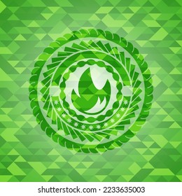 Feuersymbol in grünem Emblem mit Dreieck-Mosaikhintergrund. 