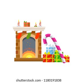 Fireplace with fire. Celebrating Christmas and new year. Red socks for gifts. Boxes of sweets and lollipops. Element of winter interior.
