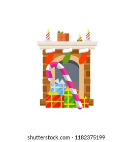 Fireplace with fire. Celebrating Christmas and new year. Red socks for gifts. Boxes of sweets and lollipops. Element of winter interior.
