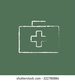 First aid kit hand drawn in chalk on a blackboard vector white icon isolated on a green background.