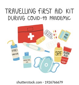 A first aid kit for travelling during Covid-19 pandemic set. Various Pills and drugs, hand sanitizer, medical face mask, bandage, electronic thermometer, sunscreen and burn aid lotion.