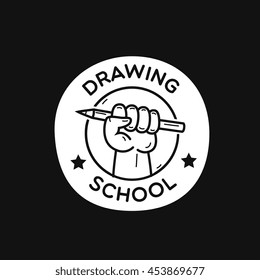 fist hold pencil, "drawing school" lettering, vector graphic art shape, vintage badge design logo, illustration isolated on black background.
