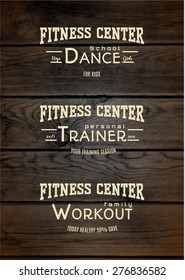 Fitness club badges logos and labels for any use, on wooden background texture