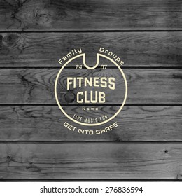 Fitness club badges logos and labels for any use, on wooden background texture