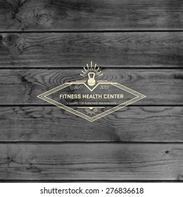 Fitness club badges logos and labels for any use, on wooden background texture
