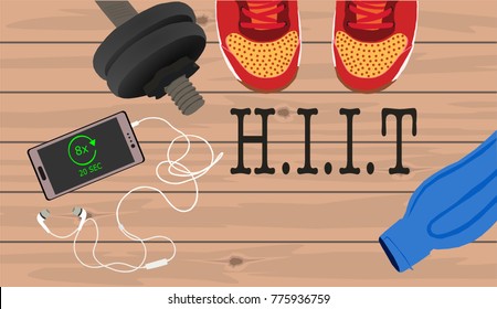 Fitness, healthy and active lifestyles concept. Dumbbells, sport shoes, smart phone with earphone and water bottle on wooden gym floor with word hiit (high intensity interval training)