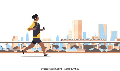 Fitness Man Running Outdoor African Guy Listening To Music With Headphones On Smartphone Healthy Lifestyle Concept Cityscape Skyscraper Background Full Length Flat Horizontal