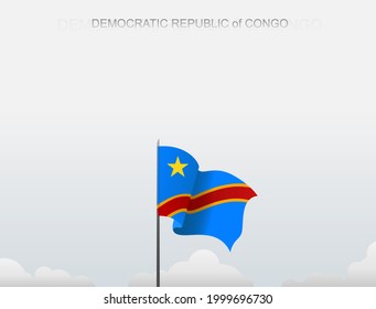 The flag of the Democratic Republic of Congo flutters on a pole standing tall under a white sky