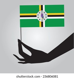 Flag of Dominica in a female hand. Vector illustration.