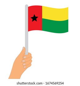 Flag of Guinea-Bissau . Hand holding a Guinea-Bissau flag - vector icon.