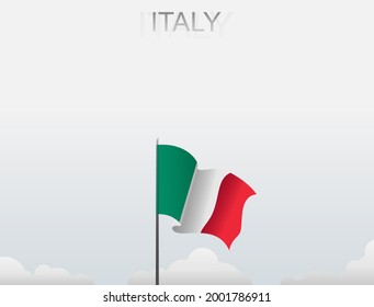 The flag of Italy flutters on a pole that stands tall under a white sky