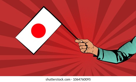 Flag of Japan in hand. The hand holds the flag of Japan