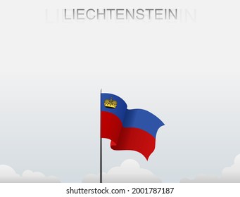 The flag of Liechtenstein flutters on a pole that stands tall against a white sky