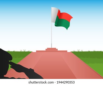 The flag of Madagascar flies above the pole in the image of a soldier saluting the flag