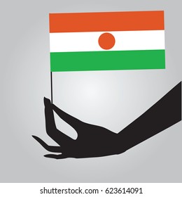 Flag of Niger in a female hand. Vector illustration.