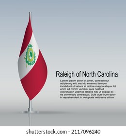 Flag of Raleigh in North Carolina (USA) hanging on a flagpole stands on the table. Vector illustration