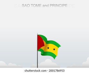 The flag of Sao Tome and Principe flies on a pole that stands tall against a white sky
