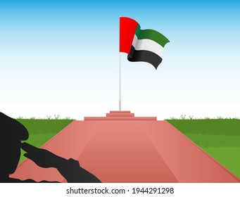 The flag of the United Arab Emirates flies over the pole in the shadow of a soldier saluting the flag