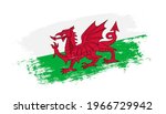 Flag of Wales country on brush paint stroke trail view. Elegant texture of national country flag