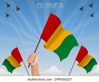 The flags of guinea fly under the blue sky