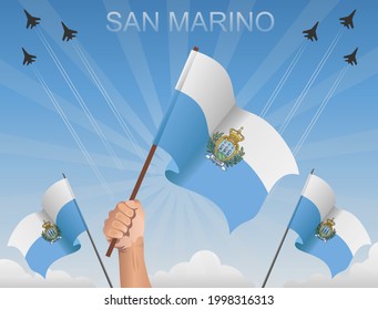 The flags of San Marino flutter under the blue sky