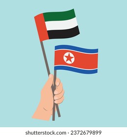 Banderas de los Emiratos Árabes Unidos y Corea del Norte, con banderas de mano