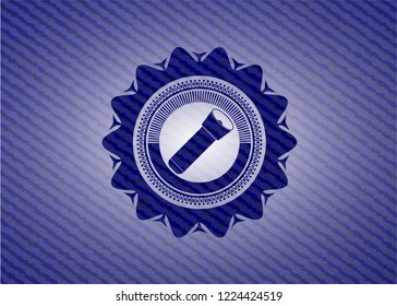 flashlight icon inside badge with denim background