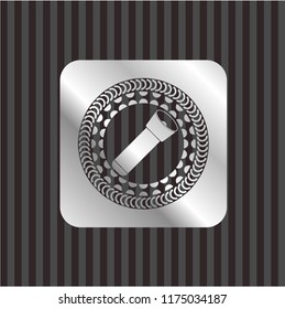 flashlight icon inside silvery emblem