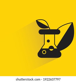 matraz y hojas con sombra sobre fondo amarillo