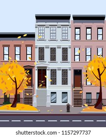 Flat cartoon style vector illustration of an autumn city street. Three-four-story houses. foliage flies from the trees. Street cityscape. Day city landscape with autumn trees in the foreground