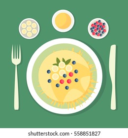 The flat composition. Pancake with honey dish decorated with berries, bananas and leaves. Dish with cutlery. 