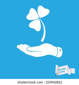 flat hand presenting Clover with three leaves sign icon. on a blue background. Saint Patrick symbol