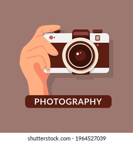 Flat illustration of photo camera with hand holding it, hands holding digital camera, isolated on brown background.