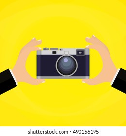 Flat illustration of Retro photo camera with hand holding it. illustration of a hand holding Vintage camera for your design