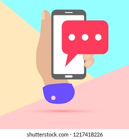 flat lay modern minimal hand holding mobile phone with chat message notification with shadow on pastel colored blue and pink background. Text messaging flat design concept.