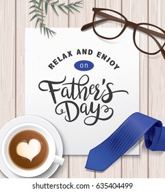 Flat lay style father`s day greeting card with cup of coffee, necktie and glasses on wooden table.